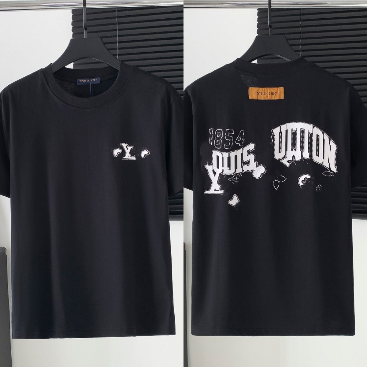 Black t-shirt with white branding on a hanger against a white background