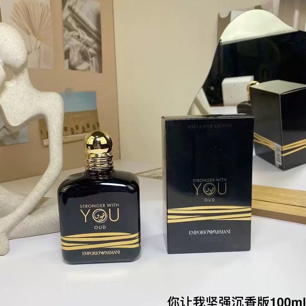 Black and gold perfume bottle with packaging on a white surface