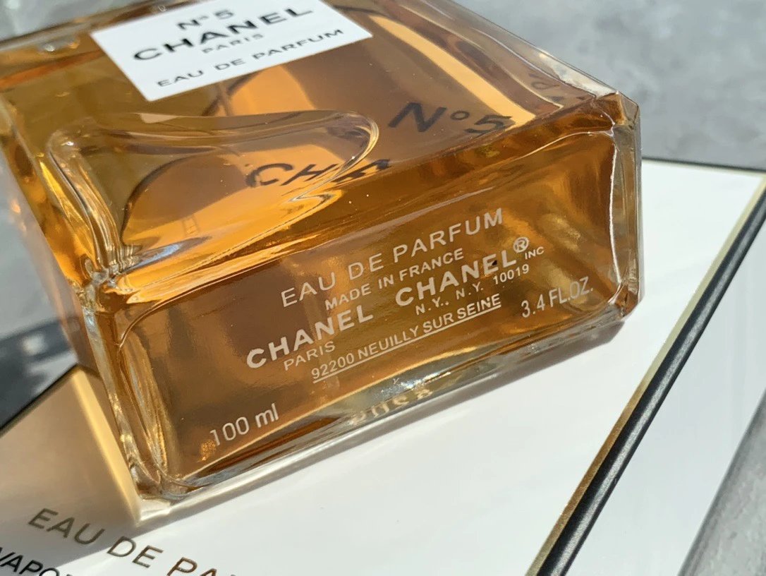 Chanel No. 5 perfume bottle on a reflective surface